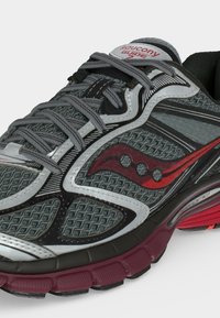 Γκρι και κόκκινο παπούτσι τρεξίματος Saucony Guide 7 με υφασμάτινο επάνω μέρος, γκρι κορδόνια και μαλακή μπορντό σόλα, πλάγια από μπροστά.