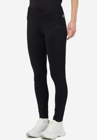 Leggings athletic neri con un design aderente, caratterizzati da una vita alta e una tasca laterale. Realizzati in tessuto stretchy per garantire flessibilità.
