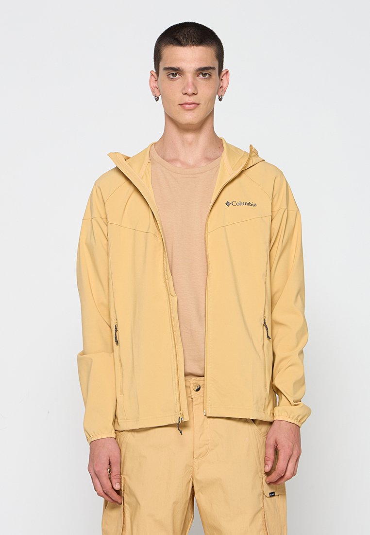 Jasnożółta, lekka kurtka z zamykanymi kieszeniami i kapturem, wykonana z gładkiego materiału. Logo marki wyświetlone na piersi.