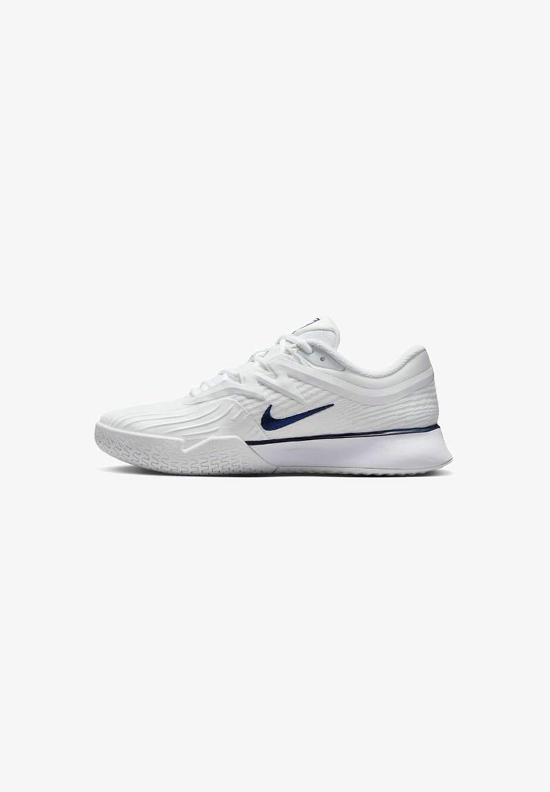 Weißer Sportschuh mit einem strukturierten Mesh-Obermaterial, navyblauen Akzenten und einer gepolsterten Sohle mit einem rutschfesten Muster. Schnürsenkel in das Design integriert.