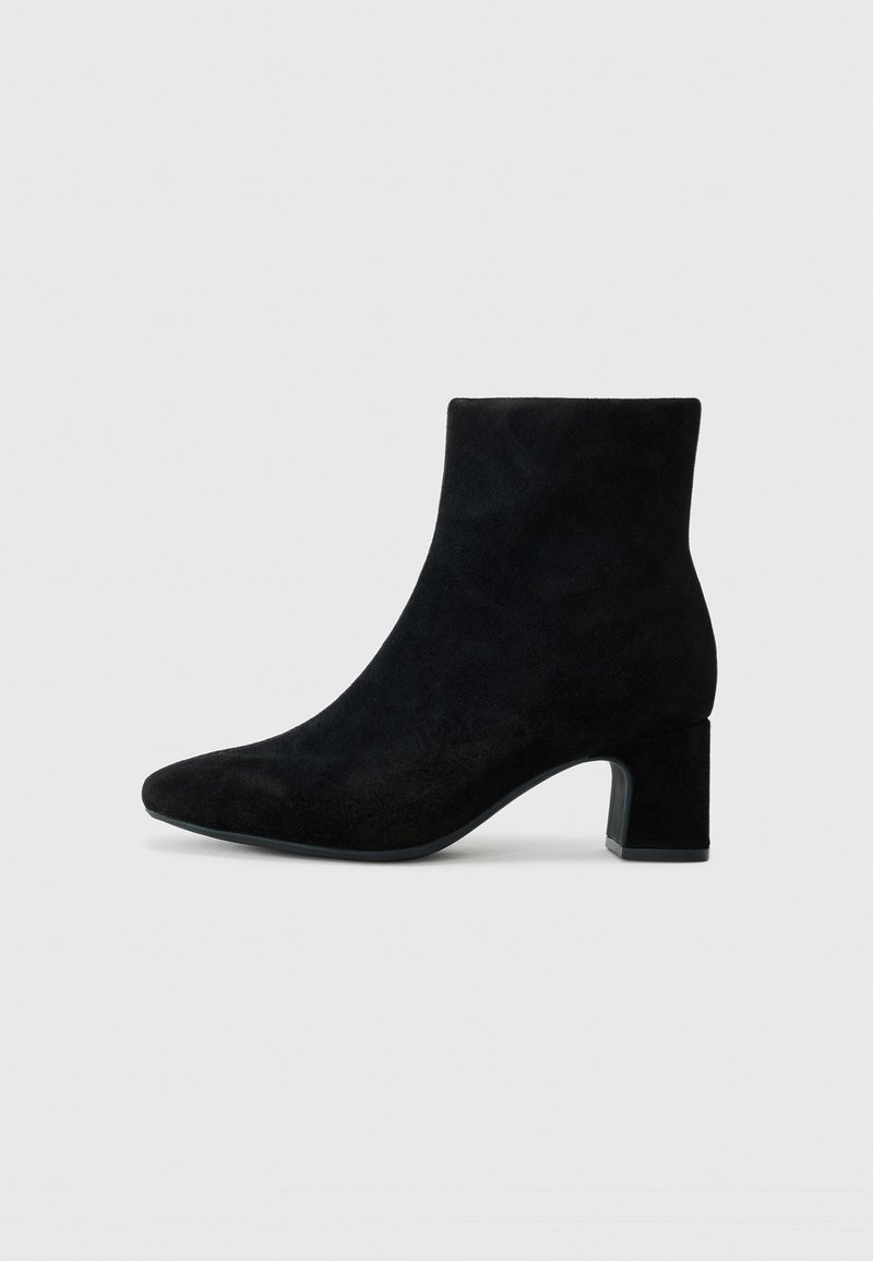 Black suede ankle boots with a pointed toe and a low block heel, featuring a smooth texture and minimalistic design.
