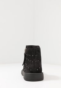 Svart mocka ank.boot med rund tå, dekorerad med silvernitar och med en sidodragkedja för enkel påtagning. Texturerad yta och tjock sula.
