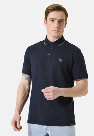 Marineblaues Poloshirt mit dezentem Strukturmuster, kontrastierendem Kragen- und Ärmelbesatz, einer Dreiknopf-Leiste und kleinem Logopatch auf der Brust.