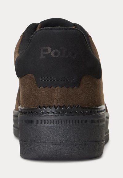 Rudos spalvos zomšinė sportinė avalynė su juodu padu ir kulno juostele, kurioje iškilumu išgraviruotas „Polo“ logotipas, matoma iš nugaros.