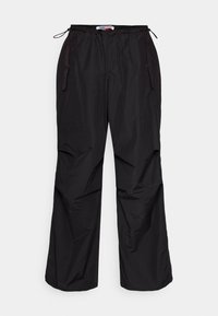 Pantaloni neri, leggeri e larghi con vita elastica e cordoncini. Presentano tasche laterali e una texture liscia e lucida.