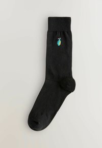 Calzino di cotone nero con polsino a coste, caratterizzato da un piccolo design ricamato e colorato di un scarabeo sul lato.