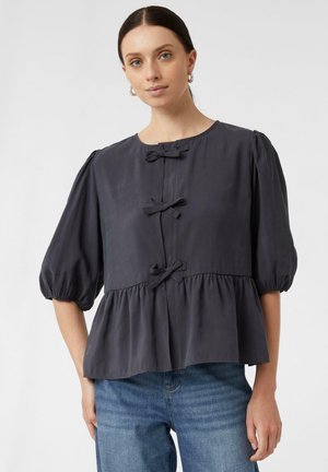 Dunkelgraue Bluse mit Puffärmeln, gefaltetem Saum und drei Schleifenakzenten auf der Vorderseite. Hergestellt aus leichtem Stoff mit glatter Textur.