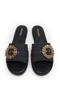 Zwarte denim instapsandalen met brede banden, voorzien van een ronde gouden accent met vierkante studs. Gestructureerde stof en gladde zolen.