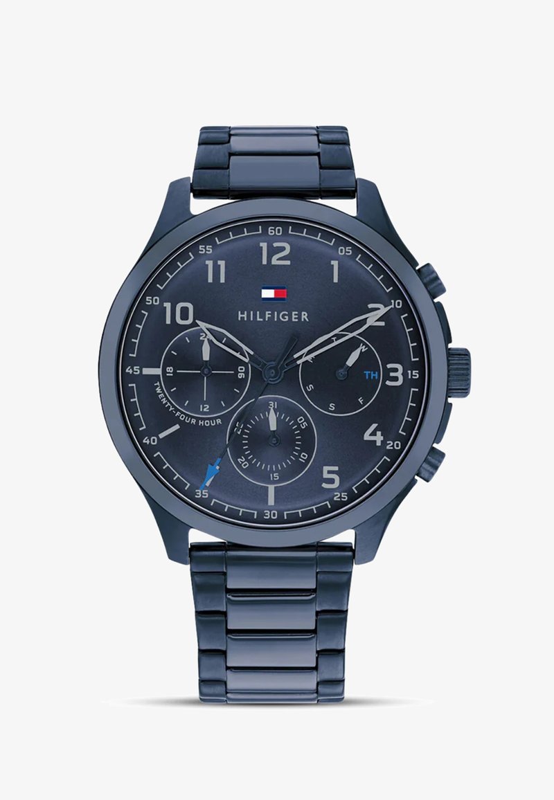 Granatowy zegarek chronograf z okrągłą tarczą, srebrnymi znacznikami godzin, trzema podtarcza i metalową bransoletą. Zawiera logo marki.