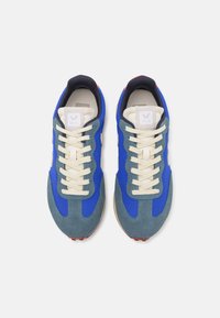 Blue and grey running shoes featuring mesh and suede materials, round laces, logo patch on tongue, and red accents on the heel.