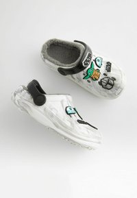 Weiße Gummi-Clogs mit grauem Fleece-Futter, die mit Dekorationen von Star-Wars-Charakteren versehen sind und über einen schwarzen Riemen für einen sicheren Sitz verfügen.