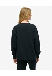 Sort sweatshirt med lange ærmer, rund halsudskæring og en afslappet pasform. Har et lille mærke øverst på ryggen. Blød tekstur, ingen synlige mønstre.