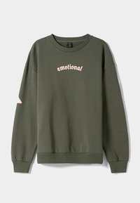 Olivenfarbener Hoodie mit gerippten Bündchen und Saum, ausgestattet mit dem Schriftzug "emotional" in pinkfarbener, kursive Schrift auf der Vorderseite und einem minimalistischen Design.