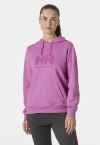 Sudadera de algodón rosa con un bolsillo frontal, capucha con cordón ajustable y un diseño de logo sutil en el pecho. Textura suave, ajuste relajado.