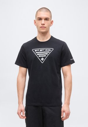 Młody mężczyzna z krótkimi włosami, ubrany w czarną koszulkę z białym logo "PFG Performance Fishing Gear" na środku klatki piersiowej.