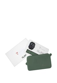 Zwarte smartwatch met digitaal display op een witte doos, naast een groene siliconen hoes. De doos bevat de merken "TECHMADE" en "GLOW".