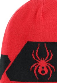 Berretto lavorato a maglia rosso e nero con una grafica di ragno rossa. La texture è liscia con un design aderente, adatto per il freddo.