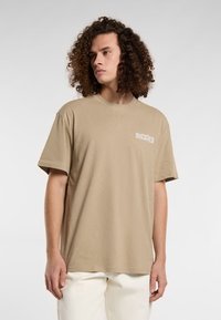 Beige short-sleeve t-shirt made of cotton, features a crew neckline and chest logo with a classic fit. Smooth texture and minimal design.