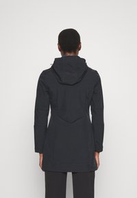 Chaqueta negra impermeable con capucha, de manga larga y ajuste entallado. Presenta detalles de costura y un corte a media longitud.
