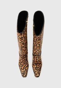 Bottes montantes en imprimé léopard avec un bout pointu, une texture lisse, une doublure noire et une fermeture éclair dorée sur le côté extérieur.