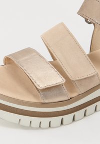 Sandalo platform beige con due fasce larghe e morbide, dettaglio metallico, soletta imbottita e suola testurizzata per maggior grip e comfort.