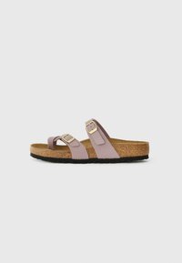 Light purple sandals with two adjustable straps, gold buckles, cork footbed, and black rubber sole. Smooth texture with minimalist design.