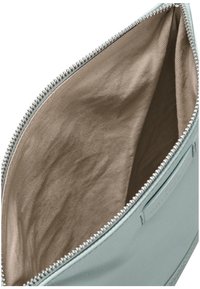 Světlomodrý kožený pytlík se stříbrným zipem. Vnitřek je hladká hnědá látka s jemnou texturou, bez dalších kapes či ozdob.
