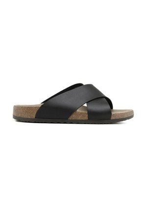 Sandale noire à talon plat avec larges brides croisées, semelle intérieure en liège et semelle extérieure noire texturée, vue de profil sur fond blanc.