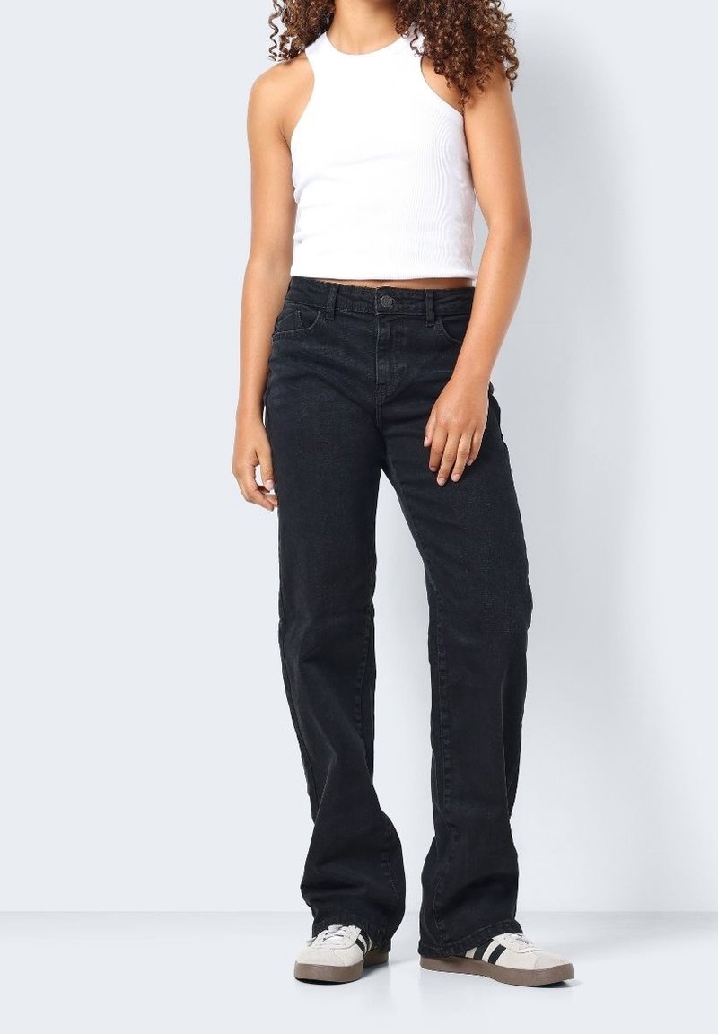 Svarta raka jeans med hög midja, gjorda av denimtyg. Bärs med en vit ärmlös topp och ljusa sneakers med svarta ränder.