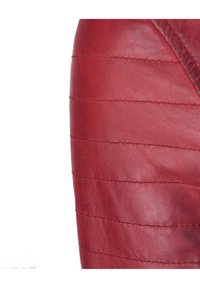 Rood leren stof met doorstikte quiltlijnen in horizontale richting, die een gladde textuur en subtiele glans tonen.