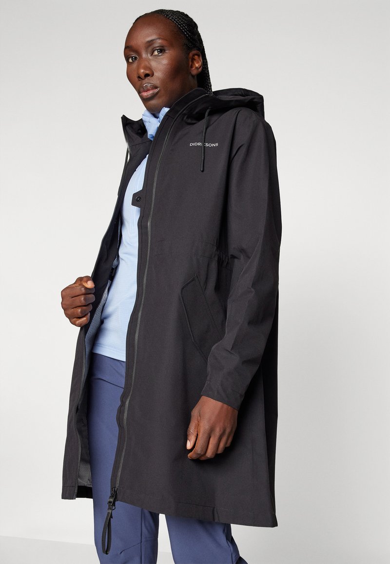 Schwarzer Regenmantel mit Kapuze, Frontreißverschluss, elastischem Bund und zwei Seitentaschen. Das Material scheint glatt und wasserabweisend zu sein.