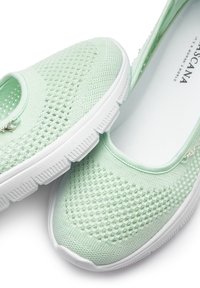 Hellgrüne Slipper aus Mesh mit weißer Gummisohle und einem kleinen dekorativen Reißverschluss-Akzent. Glatte Innenauskleidung, keine Schnürsenkel.