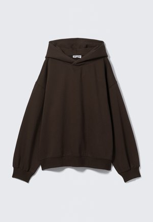 Hnědá oversized mikina s velkou přední kapsou a vysokým límcem. Vyrobena z měkké látky s žebrovanými náplety a detaily na spodním lemu.