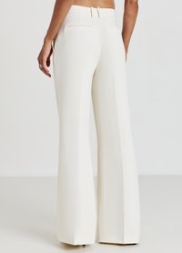 Pantalons blancs à jambe large avec une texture lisse, présentant une taille ajustée, des passants de ceinture et deux poches arrière.