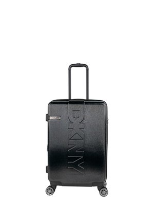 Maleta rígida negra con textura cepillada, logo en relieve "DKNY", asa retráctil y cuatro ruedas giratorias.