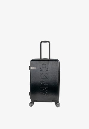 Maleta rígida negra con textura cepillada, logo en relieve "DKNY", asa retráctil y cuatro ruedas giratorias.
