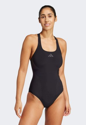 Zwarte tankini met textuur aan de zijkanten en een ronde halslijn. Heeft dunne bandjes en subtiele branding op de borst.