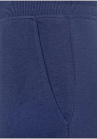 Marineblauwe sweatpants van zacht, gestructureerd materiaal, met een geribbelde tailleband en een enkele zijzak voor functionaliteit.
