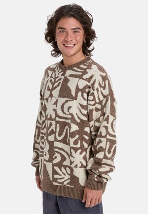 Pull en tricot présentant un motif abstrait marron et crème, à manches longues, avec un col rond et une coupe décontractée, terminé par des poignets et un ourlet côtelés.