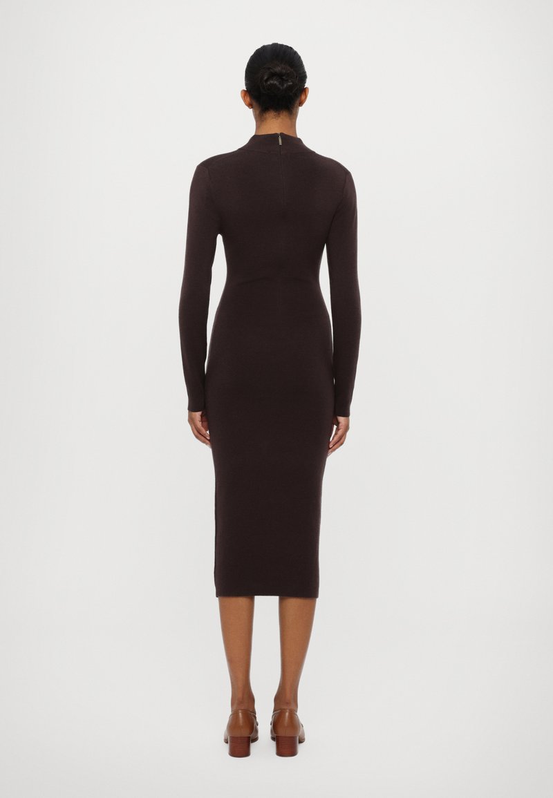 Abito aderente a maniche lunghe in tessuto knit marrone scuro, lunghezza fino al polpaccio con una discreta cerniera sul retro e design minimalista.