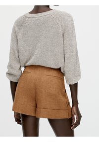 Gray knitted sweater with three-quarter sleeves, paired with brown linen shorts featuring cuffed hems and side buttons.