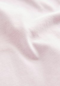 Helles rosa Baumwollgewebe mit weicher Textur und leichten Falten, das ein glattes, gleichmäßiges Webmuster zeigt.