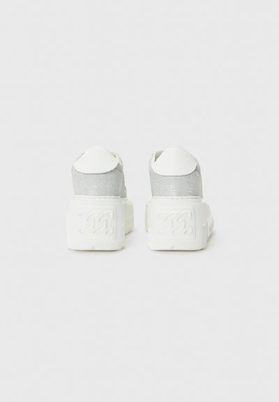 White platform sneakers with a shiny silver fabric upper, textured white sole, and smooth white heel accents. Reinforced stitching at seams.