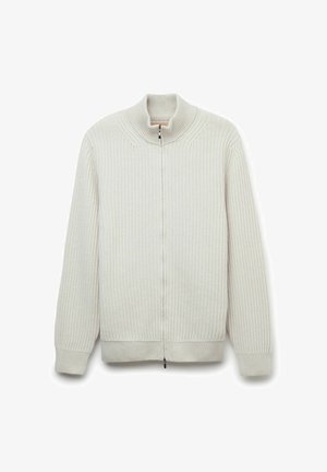 Ljus beige ribbad zip-up tröja med hög krage, med ett strukturerat mönster och stickade manschetter. Sömmar är sydda längs axlarna.