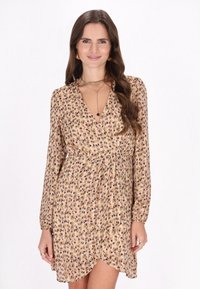 Langsleeve wikkeljurk in beige met paarse en groene bloemenprint, met een verzamelde taille en een gerafelde zoom. Zachte stoftextuur.