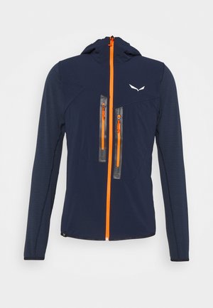 Chaqueta azul marino con cremallera frontal naranja, dos bolsillos en el pecho con paneles transparentes y mangas texturizadas de diseño ajustado.