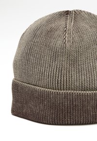 Gebreide beanie in grijstinten met een geribbelde textuur. De onderste band is donkerder, en de bovenkant heeft een subtiele gradient van licht naar donker.