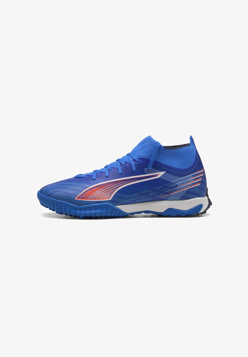 Zapatilla deportiva azul con parte superior sintética texturizada, que presenta un diseño en blanco y naranja, puntera redondeada y suela de goma flexible.