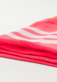 Lys rosa bomullstekstil med hvite horisontale striper, pent brettet. Stoffet har en teksturert overflate og en myk finish.