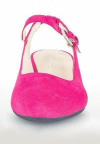 Chaussure slingback en suede rose avec un bout arrondi, une sangle à boucle ajustable et une surface douce et texturée. Logo discret sur la semelle intérieure.